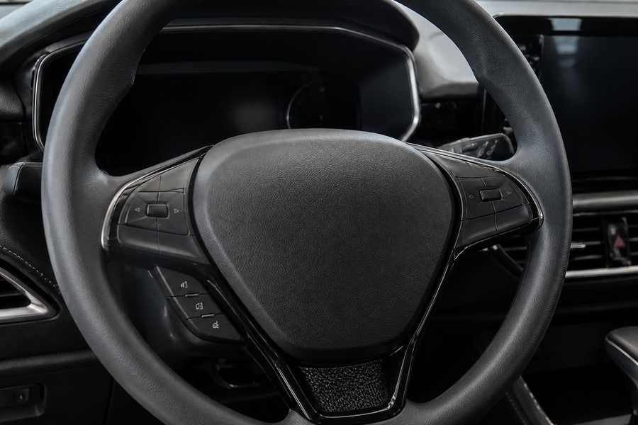 Automotive steering wheel area with protected airbag wiring